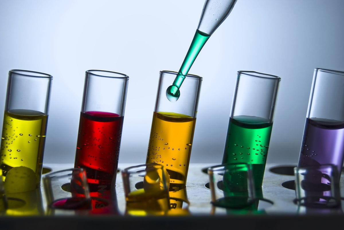 Reagenzgläser mit farbigen Flüssigkeiten und Pipette im Labor